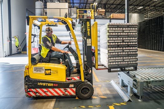 pexels-photo-1267338-1267338 A warehouse worker maneuvers a forklift to transport crates for brewing company storage.