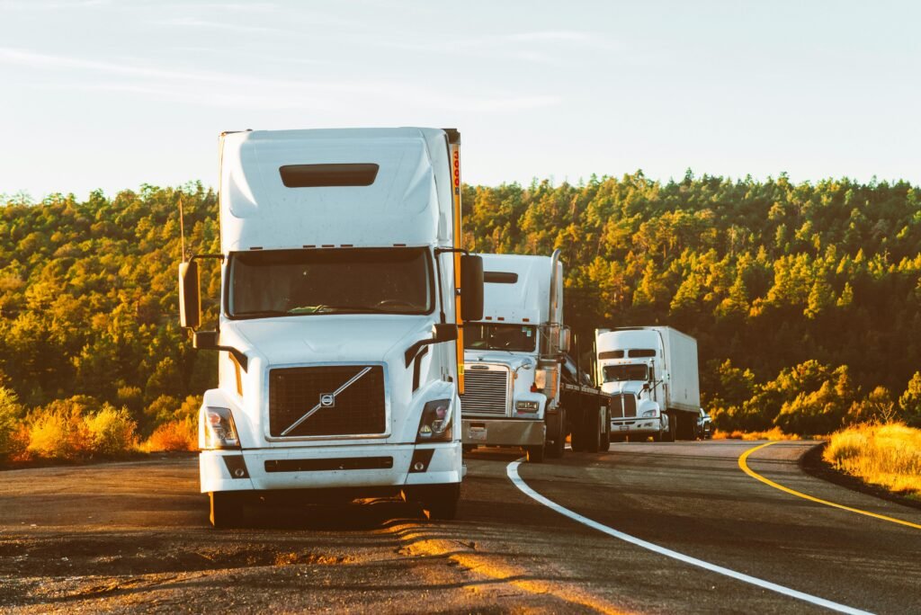 pexels-photo-2199293-2199293 Three semi trucks driving on a highway through a forested landscape in Arizona.